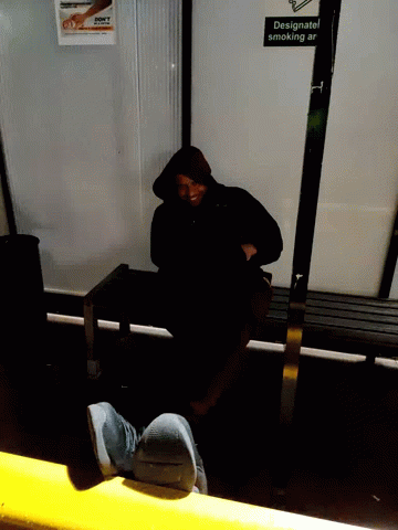 a person with his head down sitting on a bench on the subway