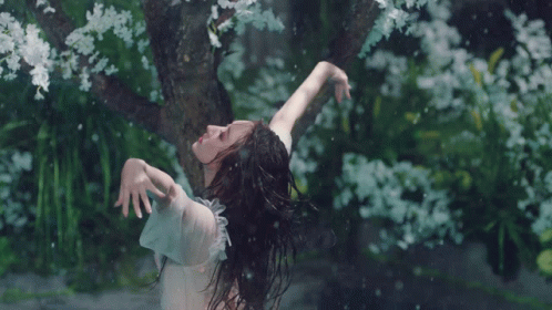 woman with long hair throwing petals in the wind