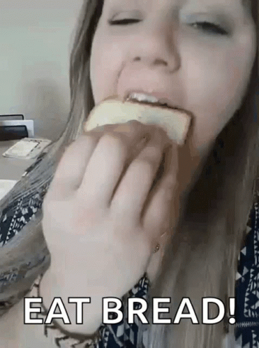 a woman sitting in a chair eating bread