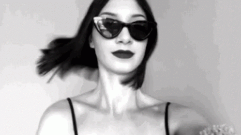 a woman with dark makeup wearing shades