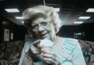 an older lady looking at the camera while eating a banana