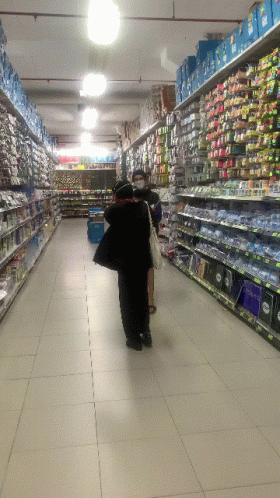 a person walking along a store aisle holding an umbrella