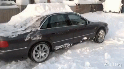 the car covered in snow parked at the entrance