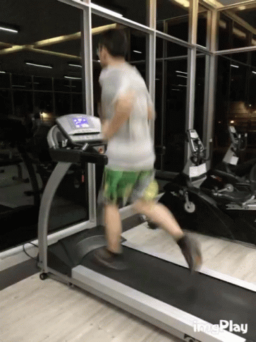 a man is running on the tread machine in the gym