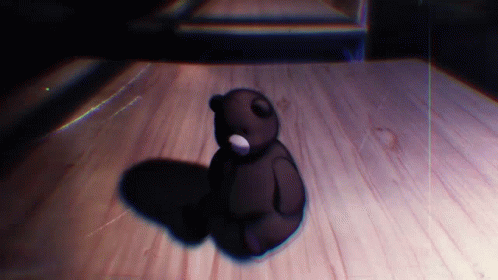 a teddy bear sitting on top of a wooden floor