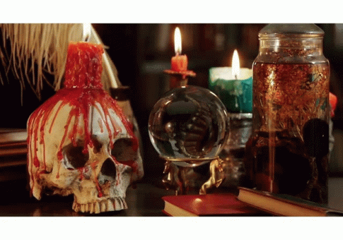 three glass items that look like skulls and candle