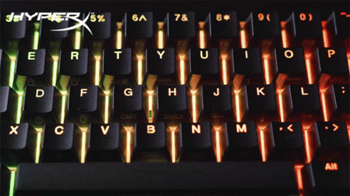 computer keyboard illuminated with blue and green lights