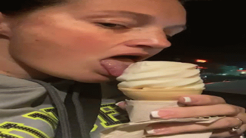 a woman biting into a cup of ice cream