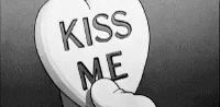 a close up of a white tombstone with a kiss me sign
