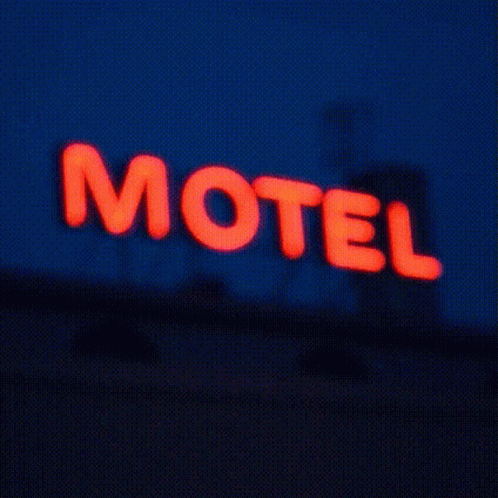 a lit up sign that says motel in front of a building