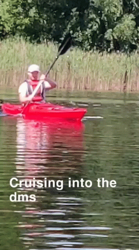 man with kayak riding in lake with trees
