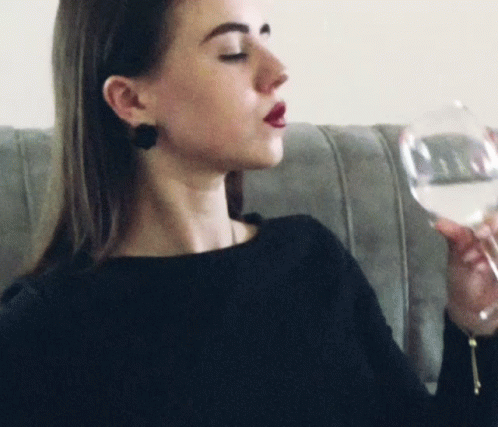 a woman holds up a glass of wine
