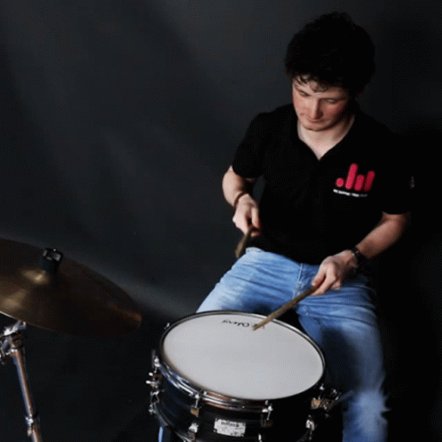 a boy with drums is playing a music instrument