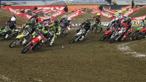 several dirt bike riders turning on and off a dirt track