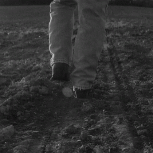 a person walking across a patch of dirt