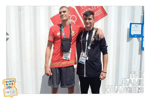 two guys are wearing matching outfits and medals