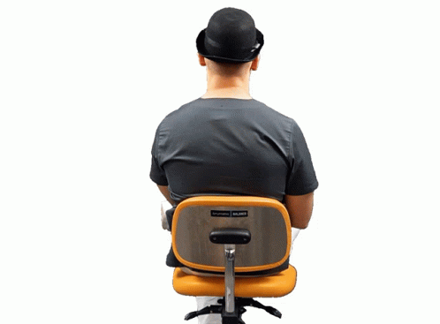 a person sitting in an office chair with a back pack