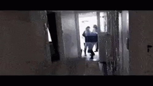 people are seen walking up a dark hallway