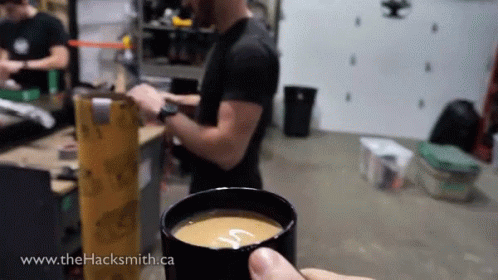 person holding up a cup and using a machine
