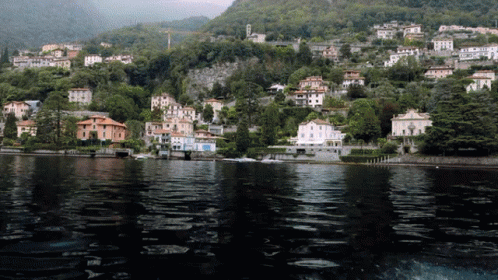 houses are situated on a mountain beside a body of water