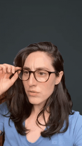 a young woman with glasses adjusting her head