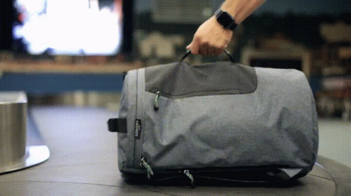a man pulls the handle of an empty suitcase