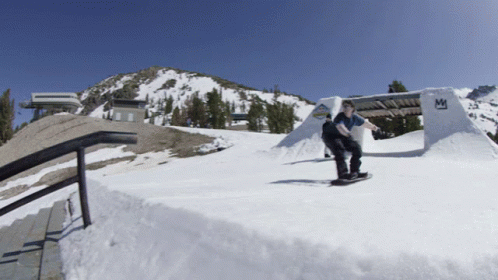 a man riding a snowboard down the side of a ramp