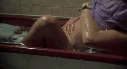 a blurry image of a woman's legs sitting in a bathtub