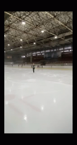 a person is skateboarding on the ice in an empty arena