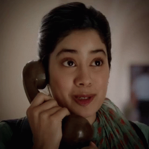 a woman making a face while talking on a telephone
