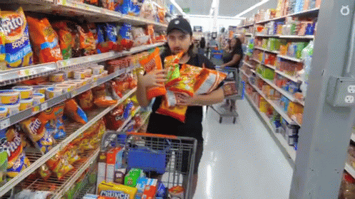two people shopping for snacks inside of a store