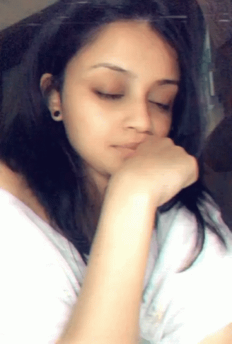 a girl resting her head on her hand and looking off to the side