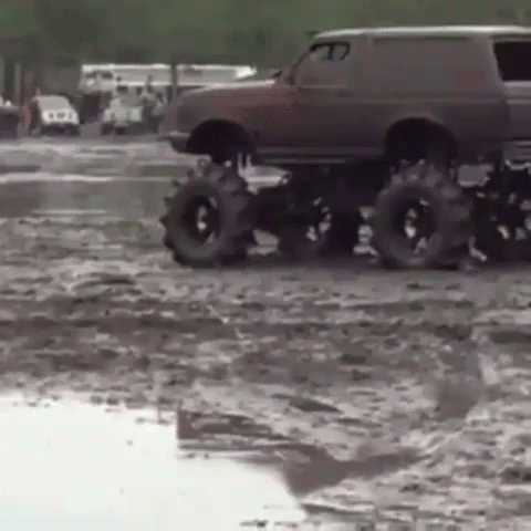 a monster truck being towed across a flooded parking lot