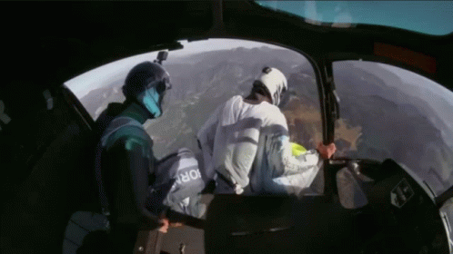the astronaut and the worker are looking through the cockpit window
