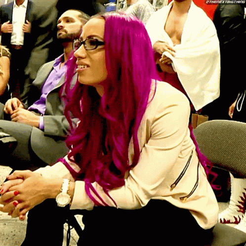 a woman with purple hair sits in the crowd