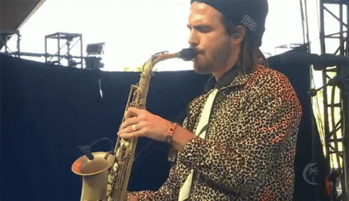 a man playing a saxophone while wearing animal print