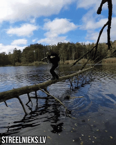 a person riding a log across a river