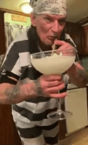 a man is using soing in a bowl and he is mixing it into a glass