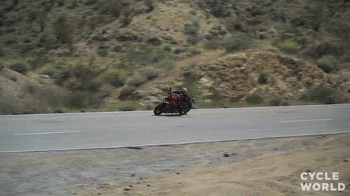 a man on a motorcycle riding down the road