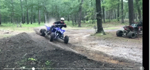 the person is riding a red motorcycle through the woods