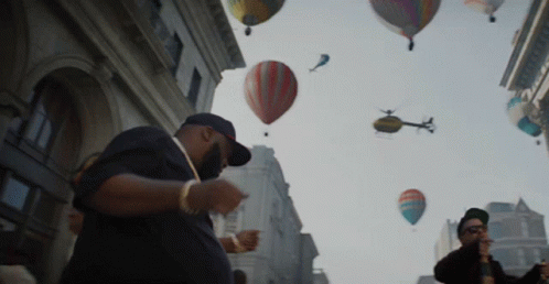 people looking at various colored balloons floating above them