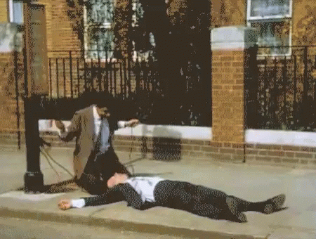 man laying on the ground with woman standing next to him