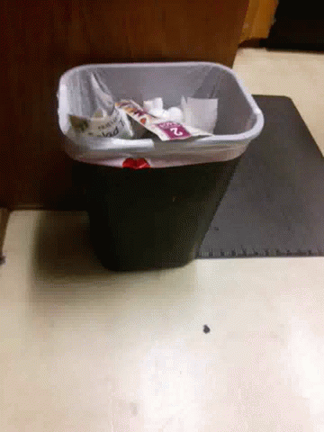 a trash can next to some paper towels and scissors