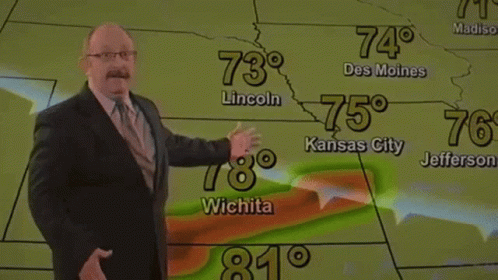 a man giving a presentation with his hand while presenting a weather map