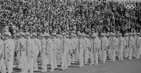 a group of men in white uniforms stand with flags
