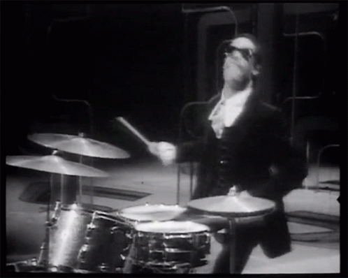 a man in a tuxedo playing the drums