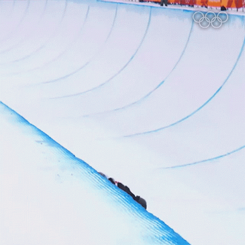 a man riding a skateboard down the side of a snow covered slope