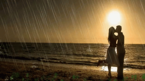 a couple kissing in the rain on the beach