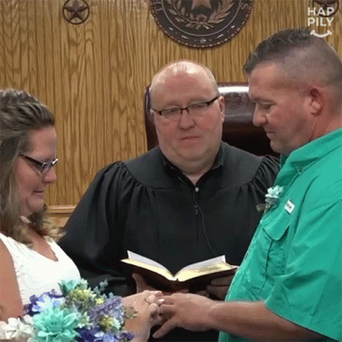 the priest is showing a woman how to hold flowers