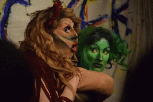 an adult in green make - up and makeup looks at the camera